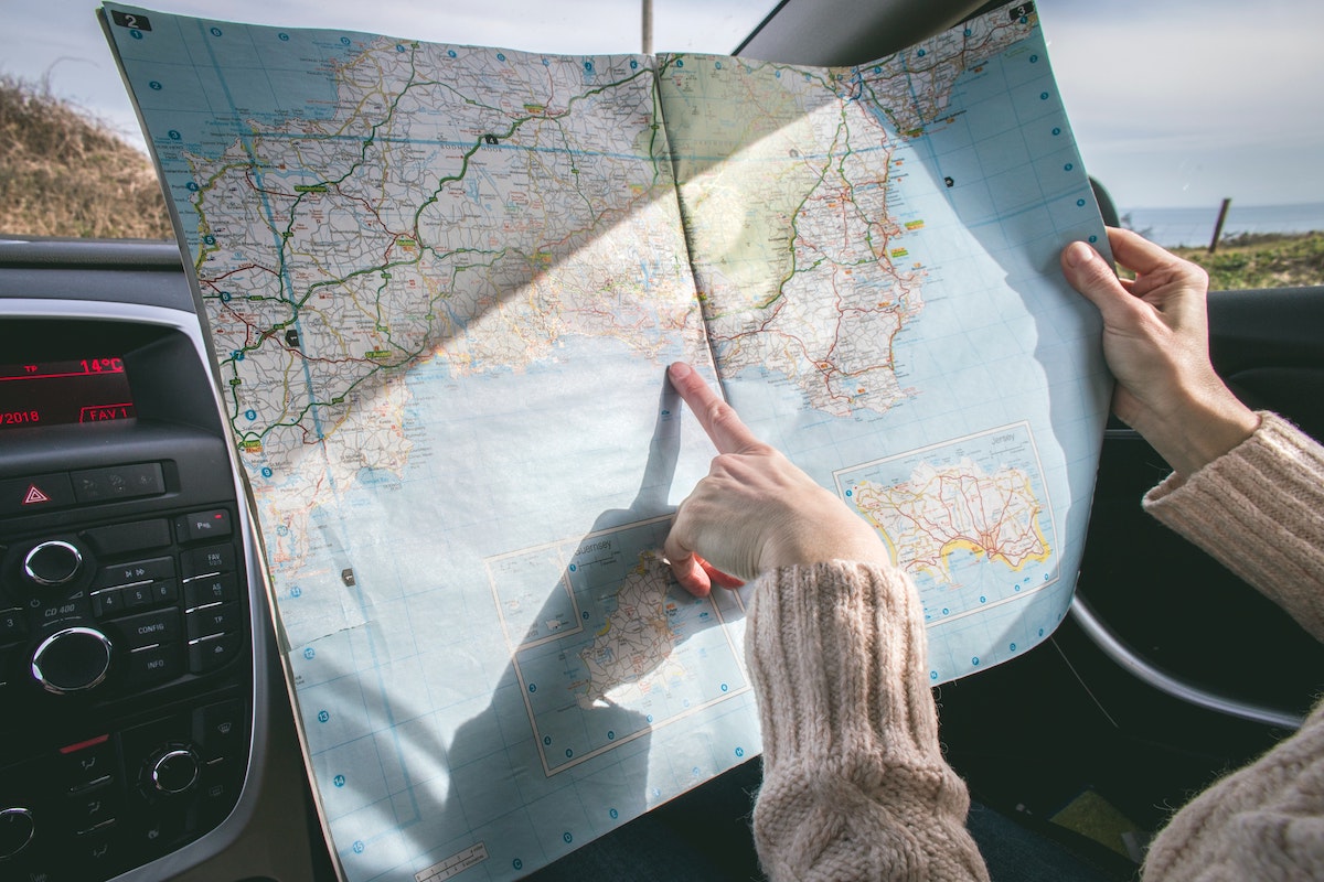 Things to keep in mind before an international road trip. Driver with map.